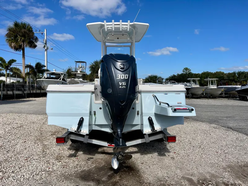 Slide: The Image of 2024 Robalo 246 Cayman boat with Yamaha 300 V6 engine in a marina. - 2