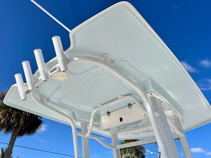 Slide: The Image of 2024 Robalo 246 Cayman T-top with rod holders against blue sky. - 21