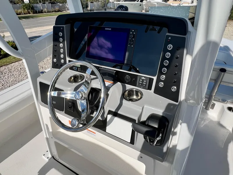 Slide: The Image of 2024 Robalo 246 Cayman boat dashboard with steering wheel and navigation system. - 29