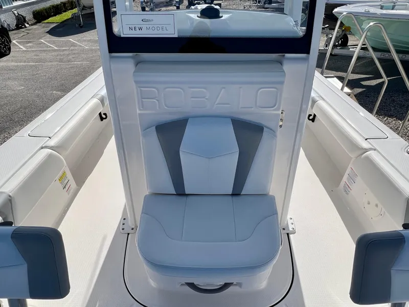 Slide: The Image of 2024 Robalo 246 Cayman boat interior with cushioned seating and New Model sign. - 34