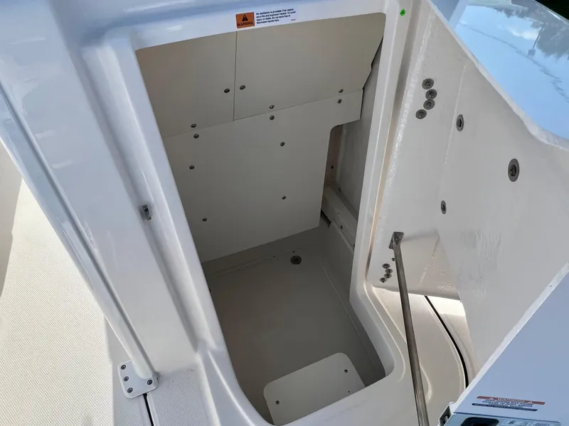 Slide: The Image of 2024 Robalo 246 Cayman storage compartment with open hatch. - 35