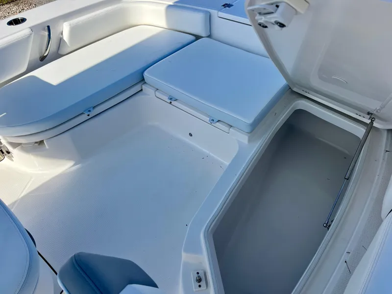 Slide: The Image of 2024 Robalo 246 Cayman boat interior with open storage compartment and cushioned seating. - 38