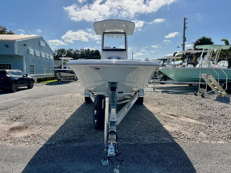 Slide: The Image of 2024 Robalo 246 Cayman boat on trailer in dealership lot under sunny sky. - 6