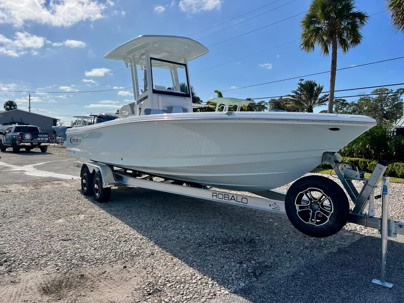 Slide: The Image of 2024 Robalo 246 Cayman boat on trailer, parked outdoors under a clear sky. - 7