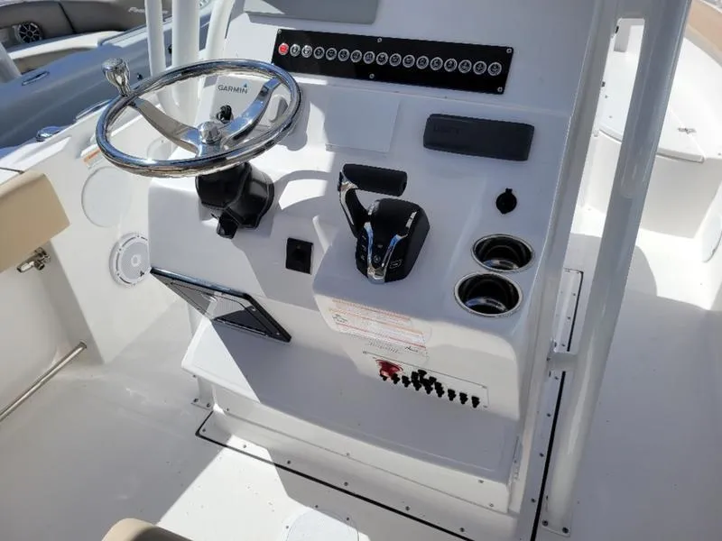 Slide: The Image of 2024 Edgewater 245 CC boat console with steering wheel and controls. - 10