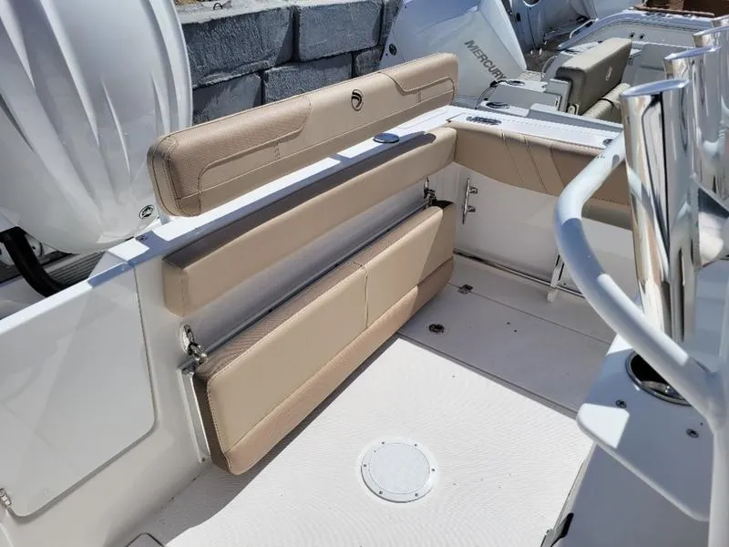 Slide: The Image of 2024 Edgewater 245 CC boat interior with beige seating and modern design. - 12