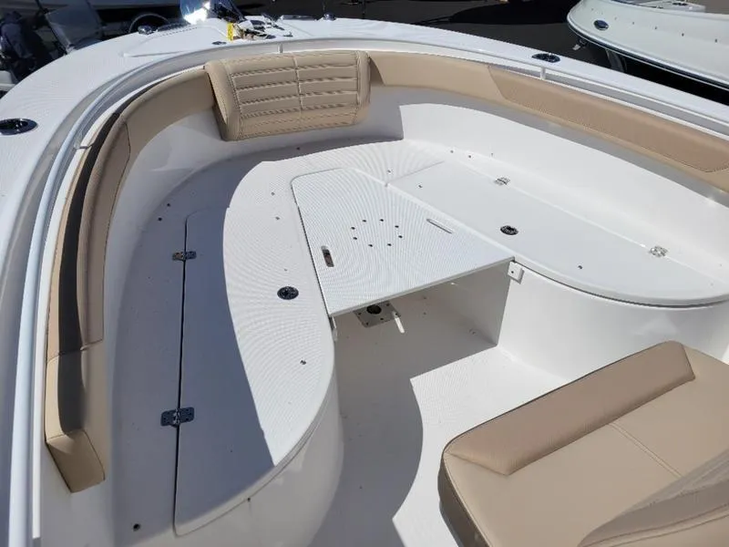 Slide: The Image of 2024 Edgewater 245 CC boat interior with beige seating and white deck. - 14