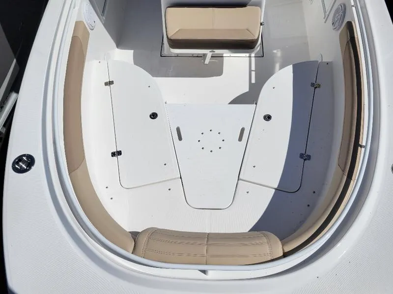 Slide: The Image of 2024 Edgewater 245 CC boat interior with beige seating and white deck. - 15
