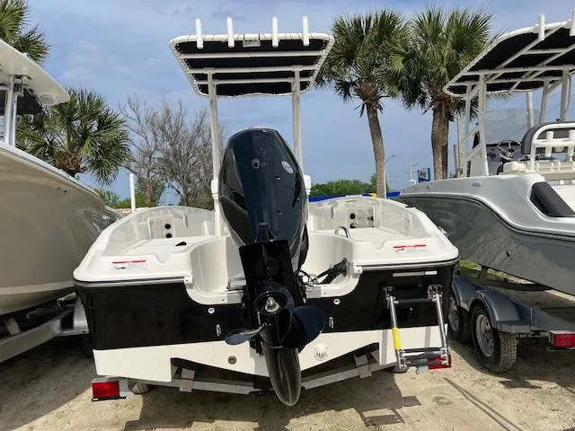 Slide: The Image of 2024 Bayliner Trophy T18Bay boat with outboard motor, parked on a trailer. - 3