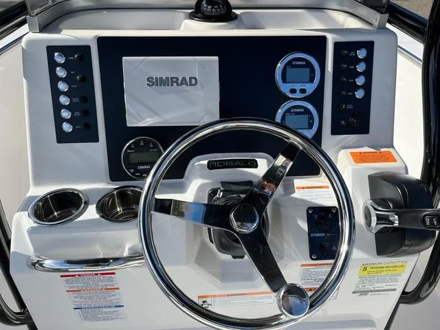 Slide: The Image of 2024 Robalo R200 boat dashboard with Simrad electronics and steering wheel. - 5