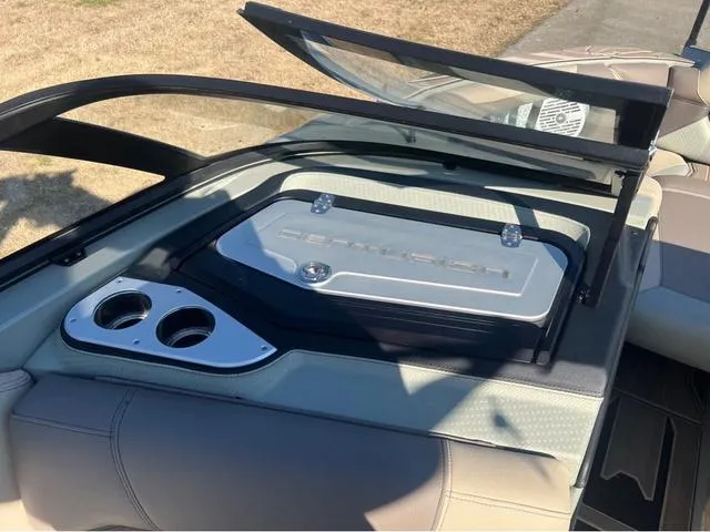 Slide: The Image of 2022 Centurion Ri230 boat interior with cup holders and storage compartment. - 11
