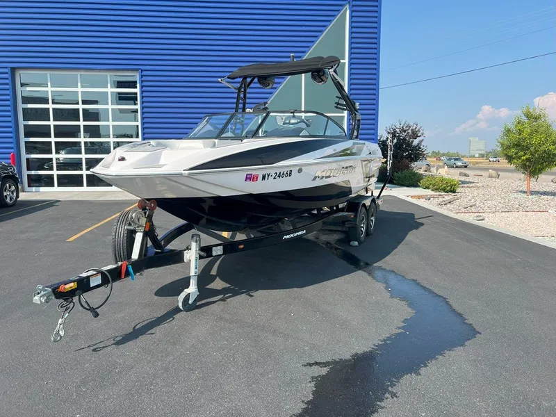 Slide: The Image of 2018 Moomba Mojo boat on trailer, parked outside a blue building. - 3