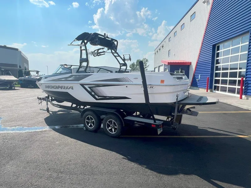 Slide: The Image of 2018 Moomba Mojo boat on trailer outside a blue and white building. - 4