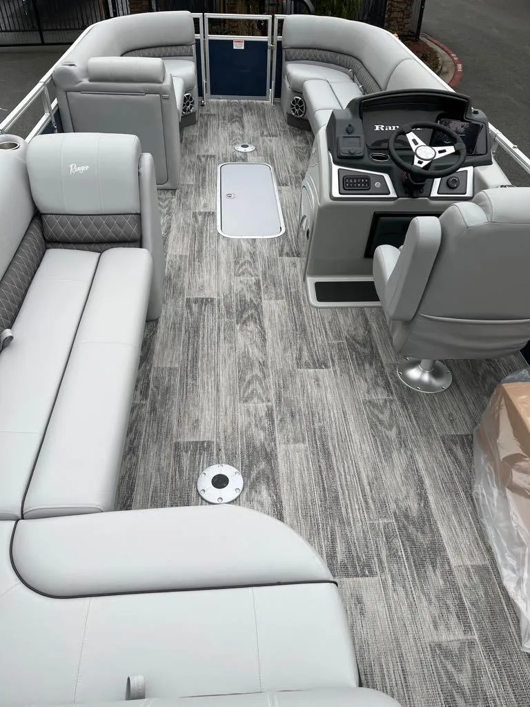 Slide: The Image of 2024 Ranger Reata 223C pontoon boat interior with luxurious seating and modern helm. - 5