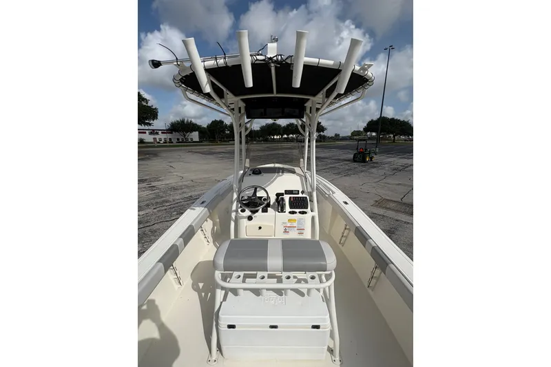 Slide: The Image of 2024 Mako 214 Center Console boat with T-top and seating, parked outdoors. - 13