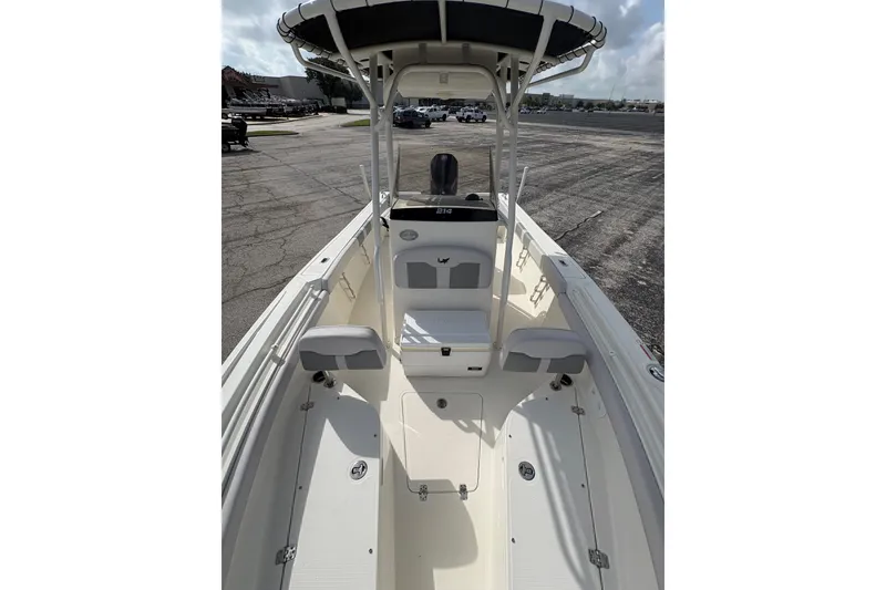 Slide: The Image of 2024 Mako 214 Center Console boat with spacious deck and seating, parked outdoors. - 14