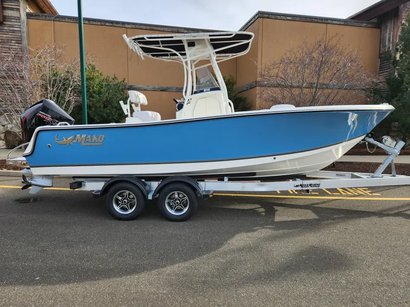 The Image of 2024 Mako 214 CC boat on trailer, blue hull, parked outdoors. - 0