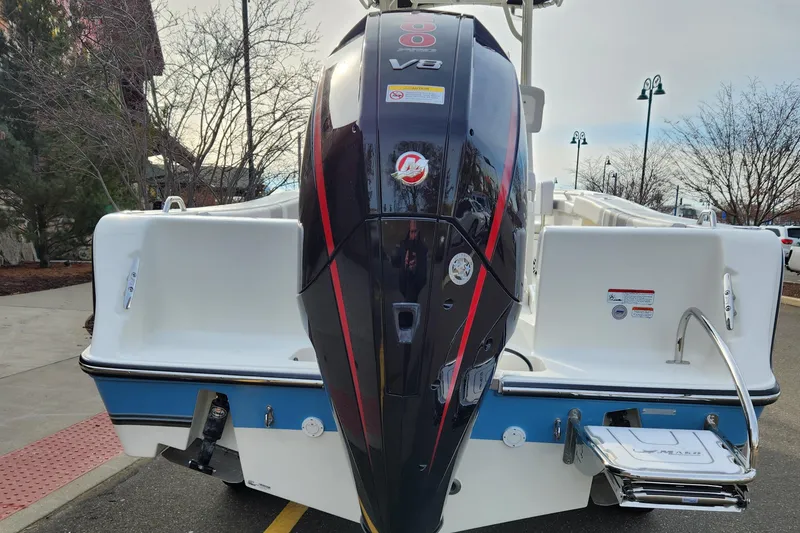 Slide: The Image of 2024 Mako 214 CC boat with powerful V8 engine, parked outdoors. - 1