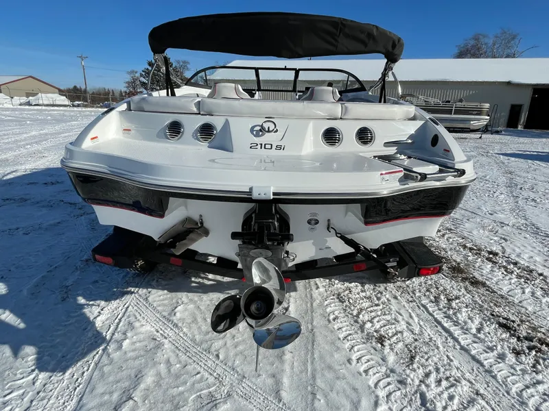 Slide: The Image of 2024 Tahoe 210 Si boat on snowy ground, rear view with propeller and seating. - 2