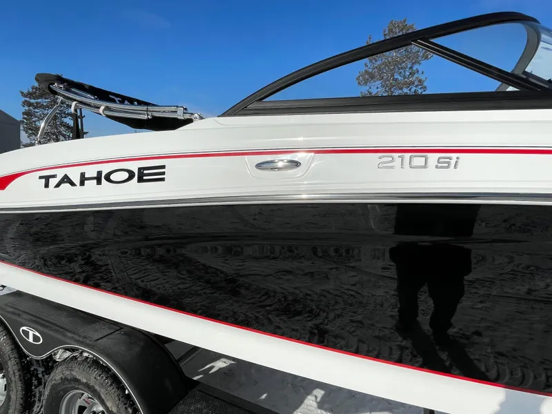 Slide: The Image of 2024 Tahoe 210 Si boat side view with sleek black and white design. - 3