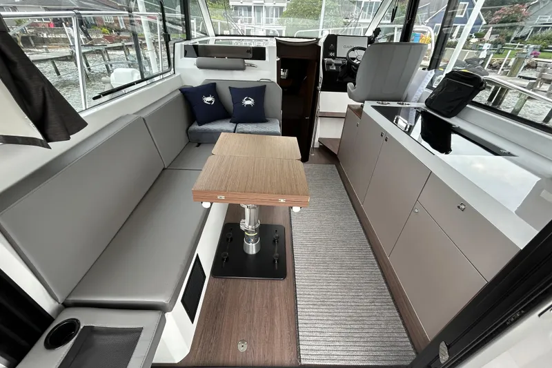 Slide: The Image of Interior of 2024 Beneteau Antares 11, featuring modern seating and sleek cabinetry. - 6