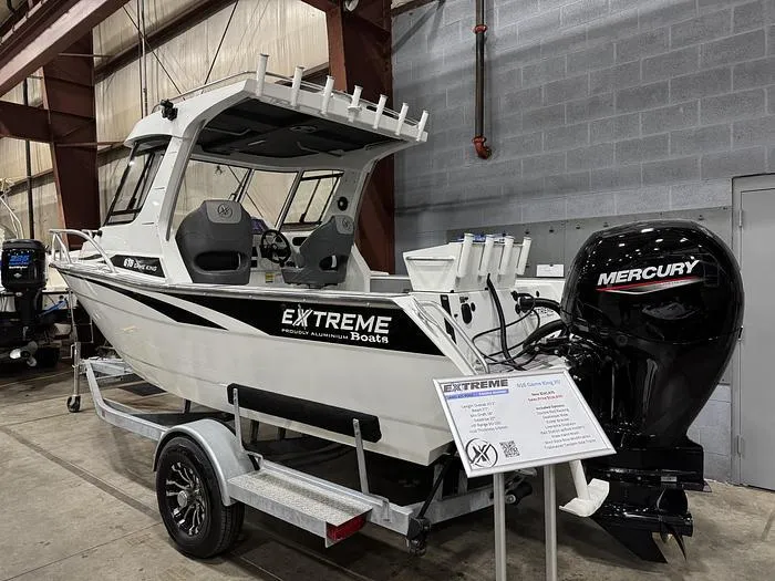 Slide: The Image of 2024 Extreme Boats 616 Game King on trailer with Mercury outboard in warehouse setting. - 0