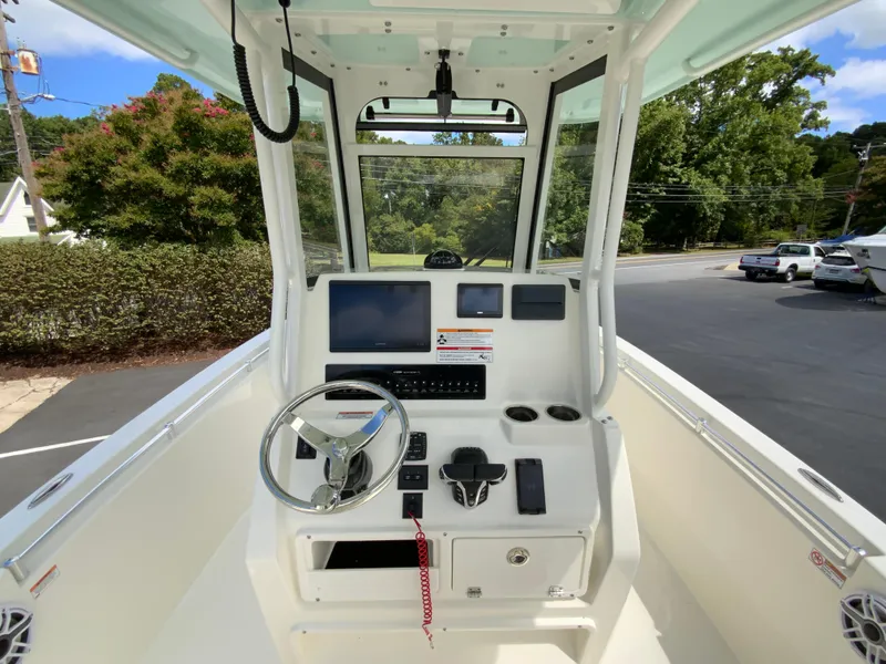 Slide: The Image of 2025 Cobia 240 Center Console boat dashboard with steering wheel and navigation screens. - 11