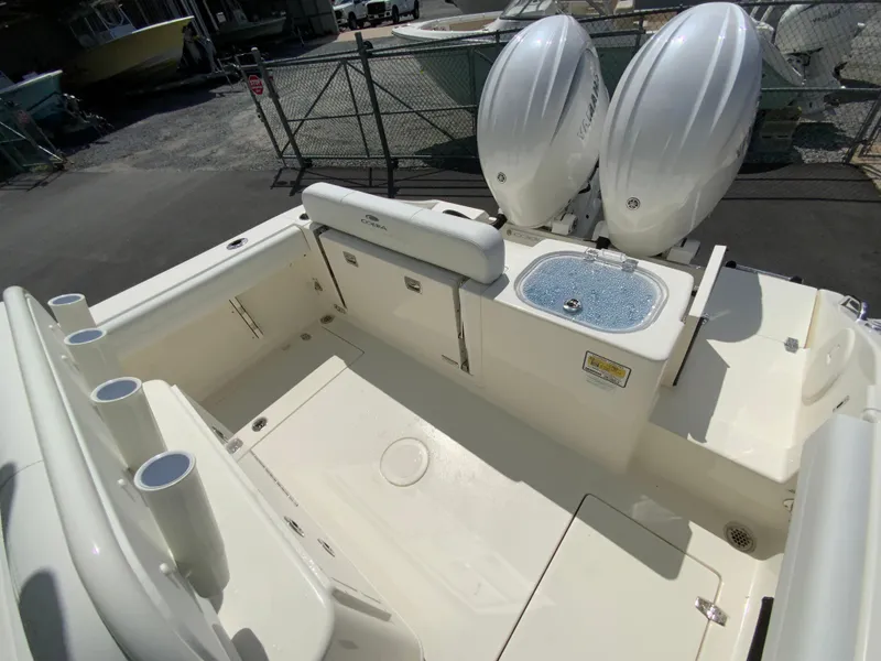 Slide: The Image of 2025 Cobia 240 Center Console boat interior with twin engines and fishing rod holders. - 13