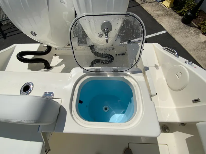 Slide: The Image of 2025 Cobia 240 Center Console boat with open livewell on deck. - 16