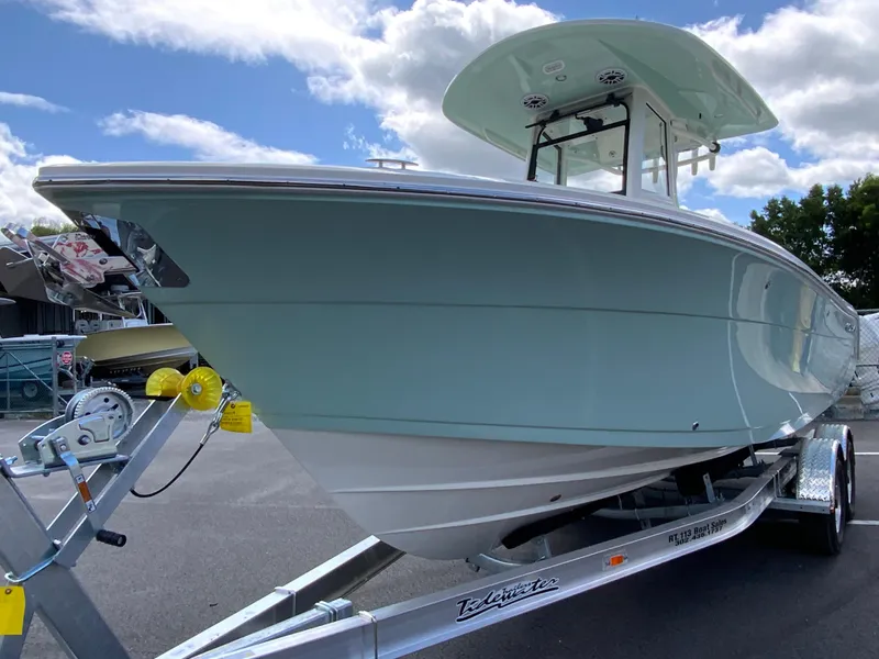 Slide: The Image of 2025 Cobia 240 Center Console boat on trailer under blue sky. - 4