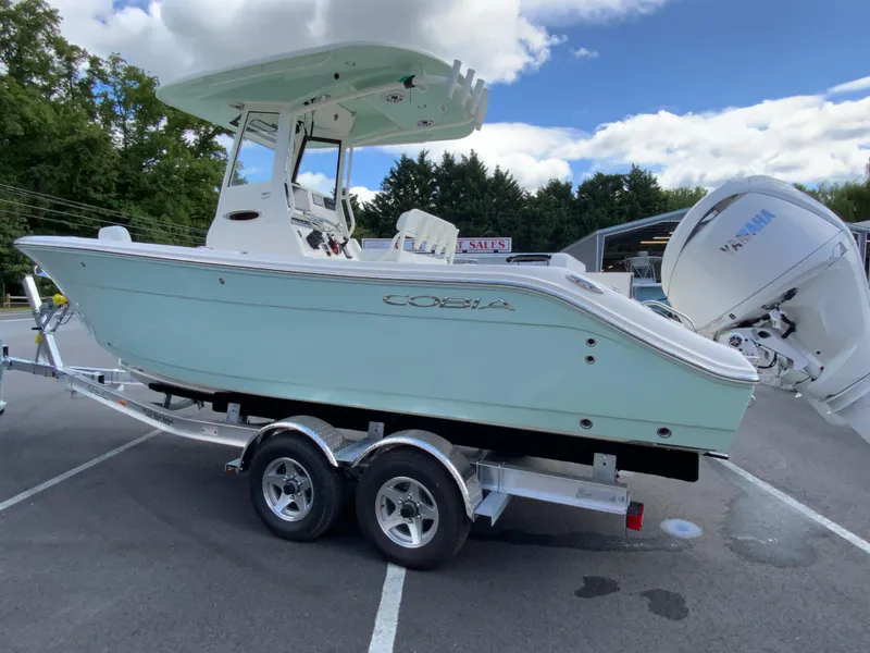 Slide: The Image of 2025 Cobia 240 Center Console boat on trailer, parked outdoors. - 6
