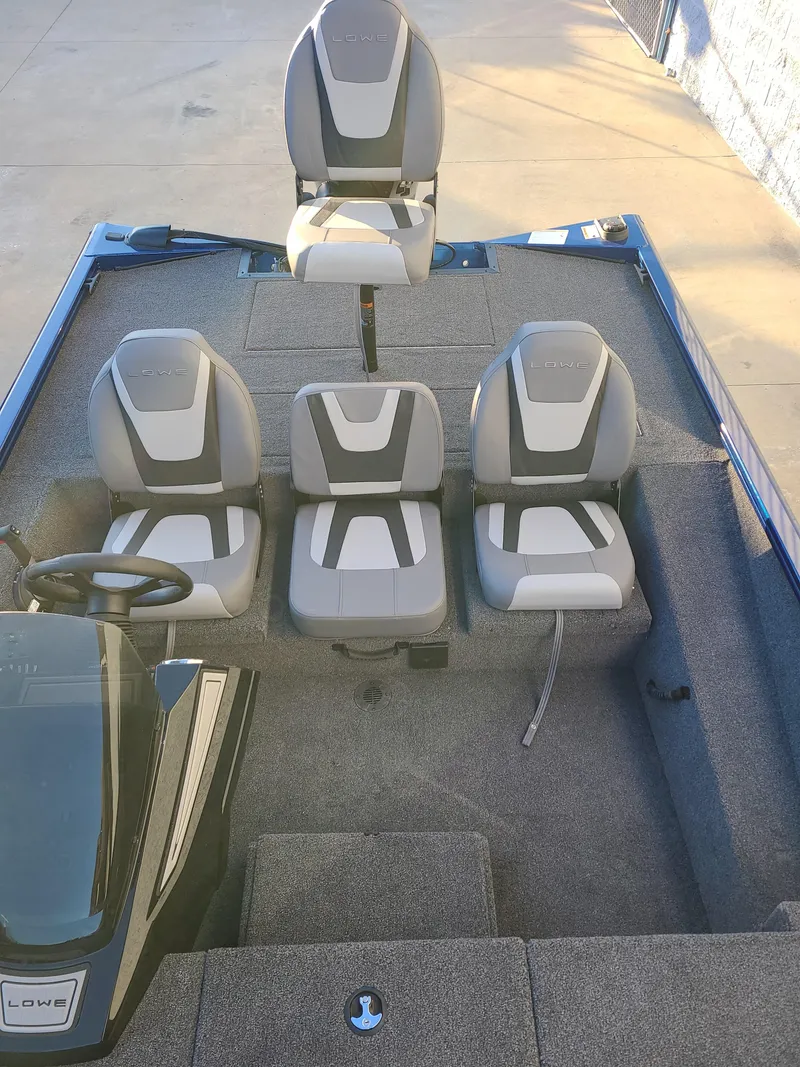 The Image of 2024 Lowe ST195B boat interior with four gray seats on a carpeted deck. - 1