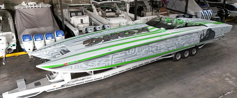 Slide: The Image of 2021 Skater 50 powerboat with green and gray design, parked in a marina. - 13