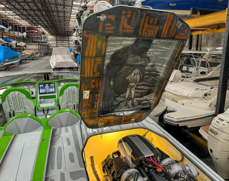 Slide: The Image of 2021 Skater 50 boat with custom artwork, vibrant interior, and powerful engine in a boat storage facility. - 19
