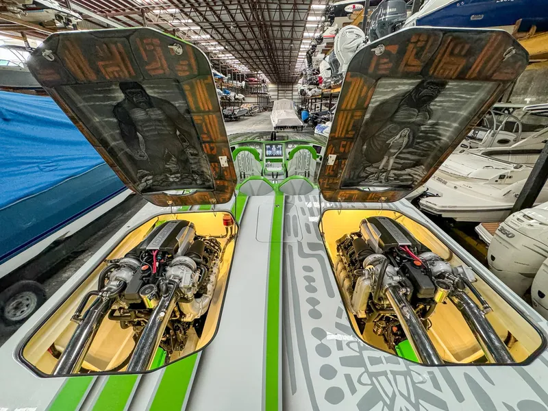 Slide: The Image of Skater 50 boat engines, open hatches, vibrant green and gray design, stored in a warehouse. - 24
