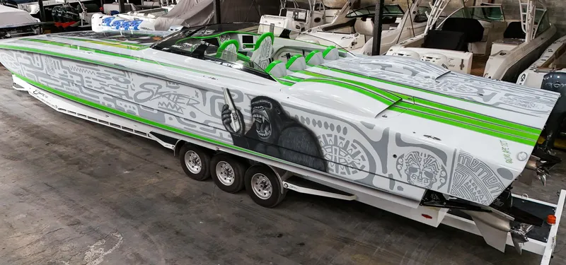 Slide: The Image of 2021 Skater 50 speedboat with green accents and intricate graffiti design in a showroom. - 34