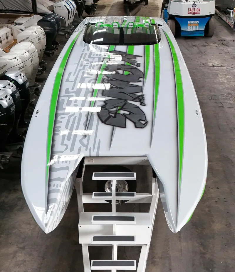 Slide: The Image of 2021 Skater 50 boat with green and gray design in a warehouse. - 39