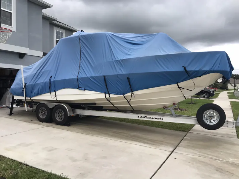 Slide: The Image of 2016 Boston Whaler 270 Dauntless boat covered on trailer in driveway. - 14