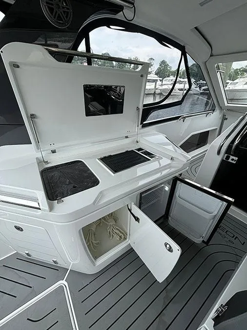 Slide: The Image of 2024 Galeon 325 GTO yacht interior with open storage compartments and kitchenette. - 7