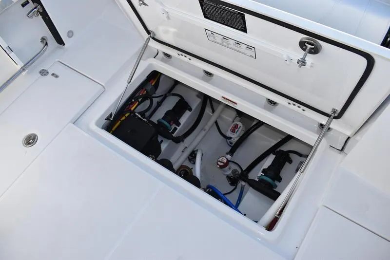 Slide: The Image of 2024 Blackfin 252DC boat storage compartment with visible wiring and equipment. - 21