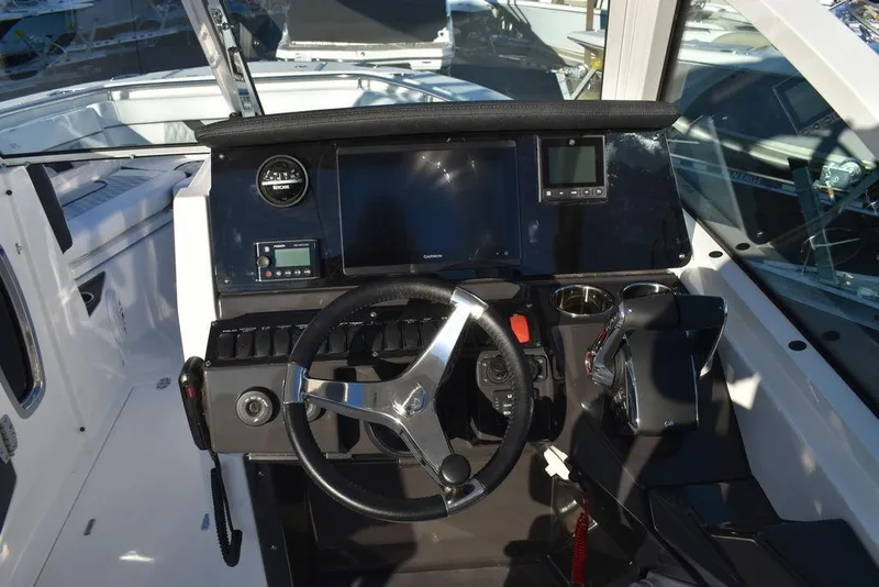 Slide: The Image of 2024 Blackfin 252DC boat dashboard with steering wheel and navigation controls. - 43