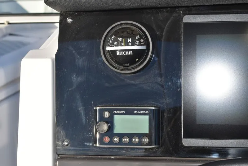 Slide: The Image of 2024 Blackfin 252DC dashboard with Ritchie compass and Fusion MS-NRX300 control panel. - 46