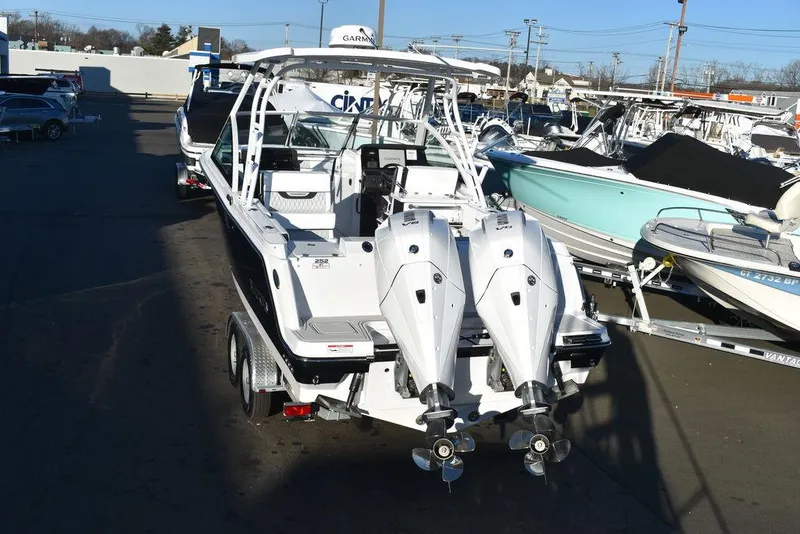 Slide: The Image of 2024 Blackfin 252DC boat with dual engines on a trailer in a marina. - 5