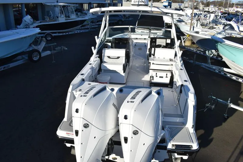 Slide: The Image of 2024 Blackfin 252DC boat with dual outboard engines, docked among other boats. - 7