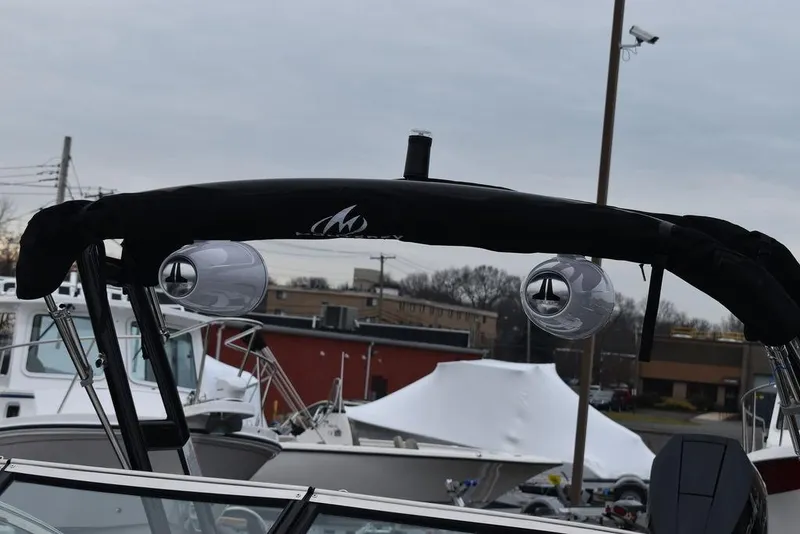 Slide: The Image of 2024 Monterey 275SS boat with black canopy and speakers in marina. - 19