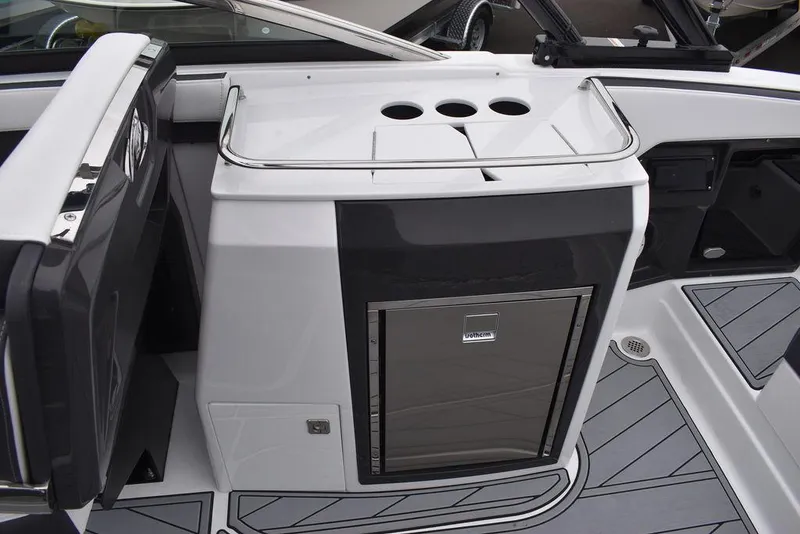 Slide: The Image of 2024 Monterey 275SS boat interior with built-in refrigerator and cup holders. - 45