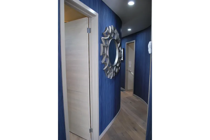 Slide: The Image of Curved hallway with blue walls, decorative mirror, and wooden flooring on Adonia Azul Trip. - 24