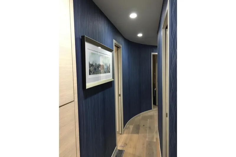 Slide: The Image of Narrow hallway with blue walls, framed artwork, and recessed lighting on Adonia Azul Trip #1. - 28