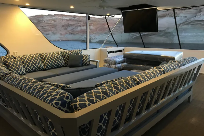 Slide: The Image of Luxurious boat interior with patterned blue seating, large windows, and scenic water view. Adonia Azul Trip 2017. - 36