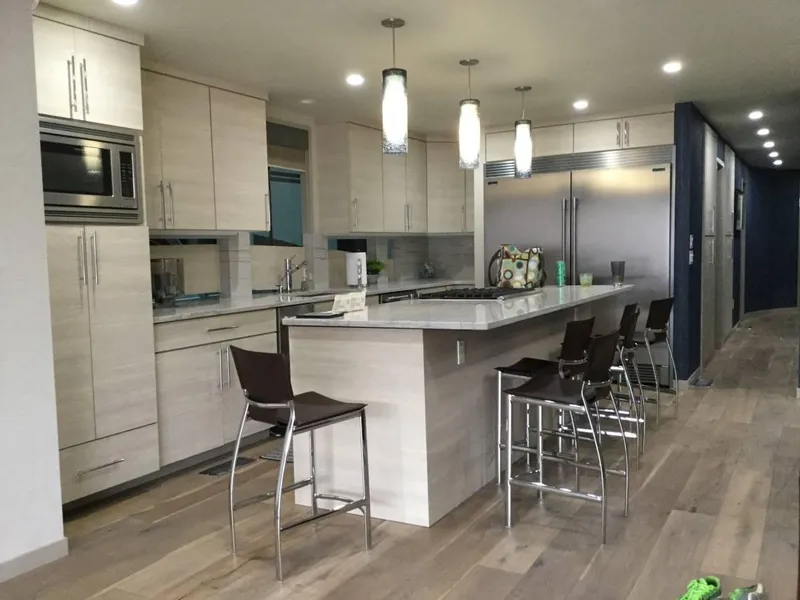 Slide: The Image of Modern kitchen with sleek cabinetry, island seating, pendant lighting, and stainless steel appliances, 2017 Adonia Azul Trip. - 9
